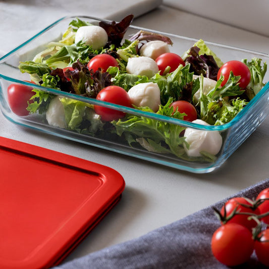 Glass container with salad on a white surface