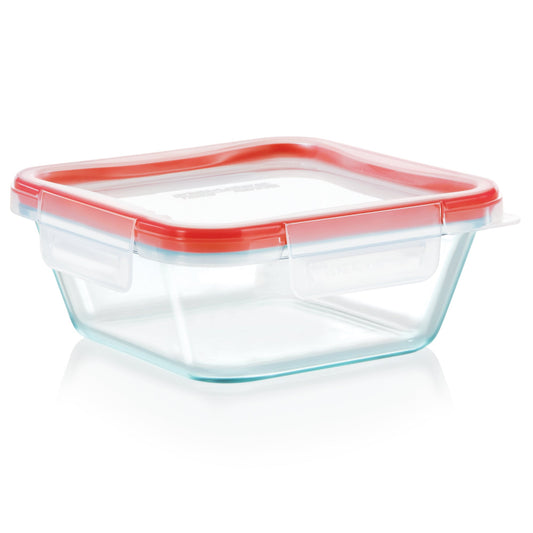 Clear glass food storage container with a red lid on a white background