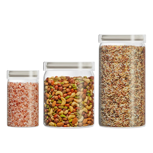Three glass jars with metal lids containing different types of food on a white background