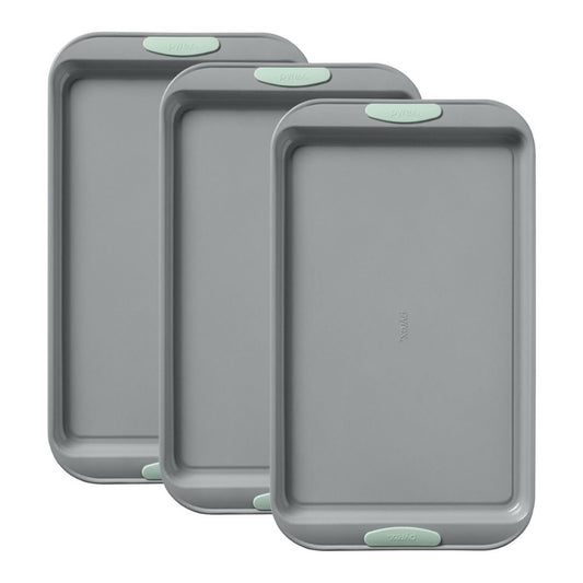 Three gray baking trays with green edges on a white background