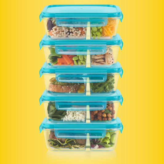 Stack of transparent food containers with blue lids filled with various vegetables on a yellow background