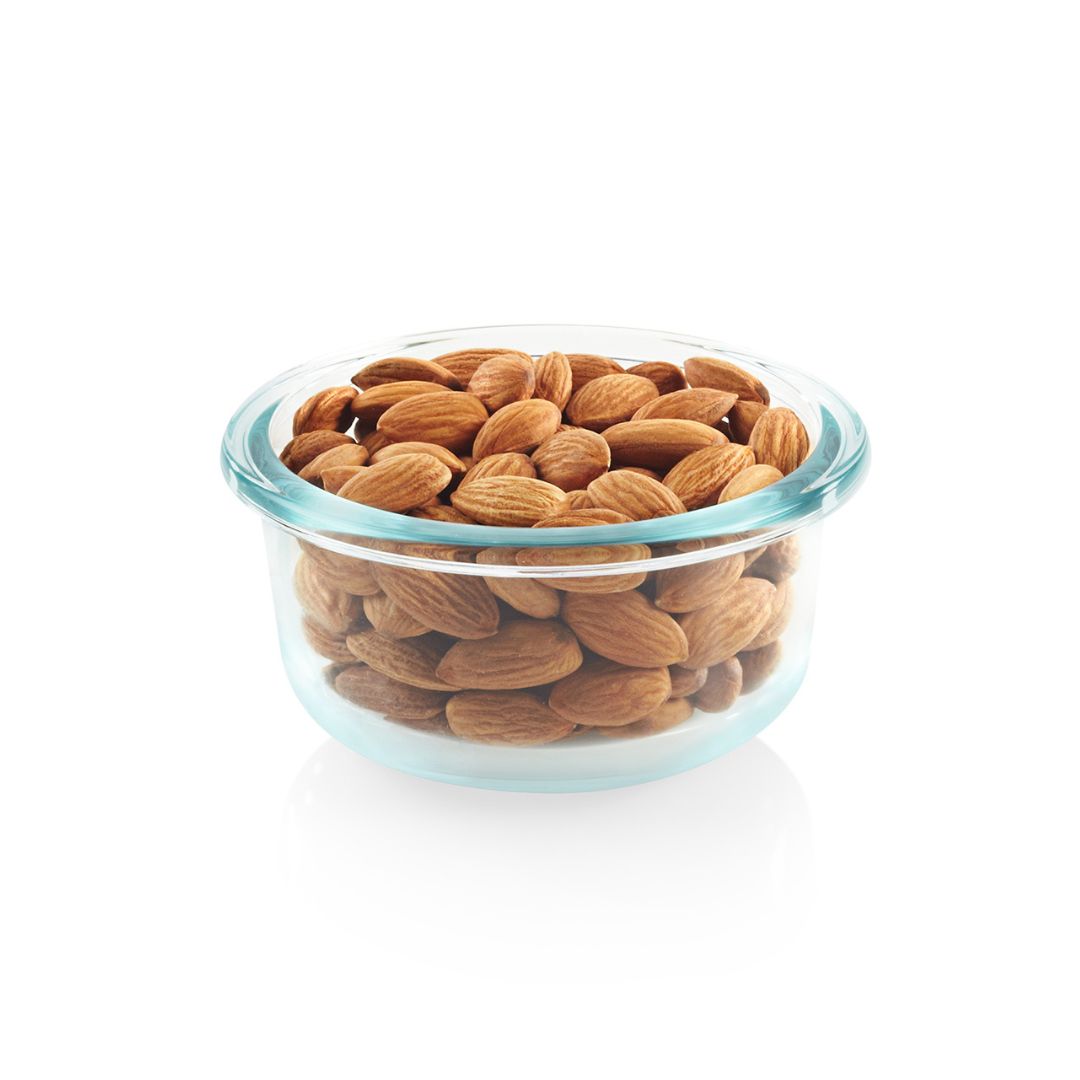 Glass bowl filled with almonds on a white background