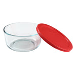Clear glass bowl with a red lid on a white background