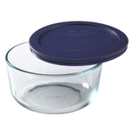 Clear glass food storage container with a blue lid on a white background
